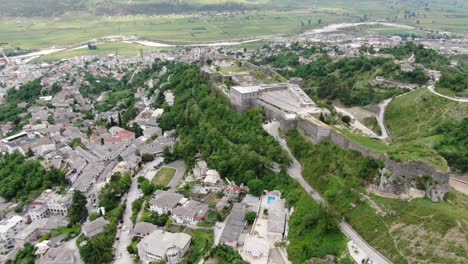 drone view in albania flying in gjirokaster town over a medieval castle on high ground lateral and top view
