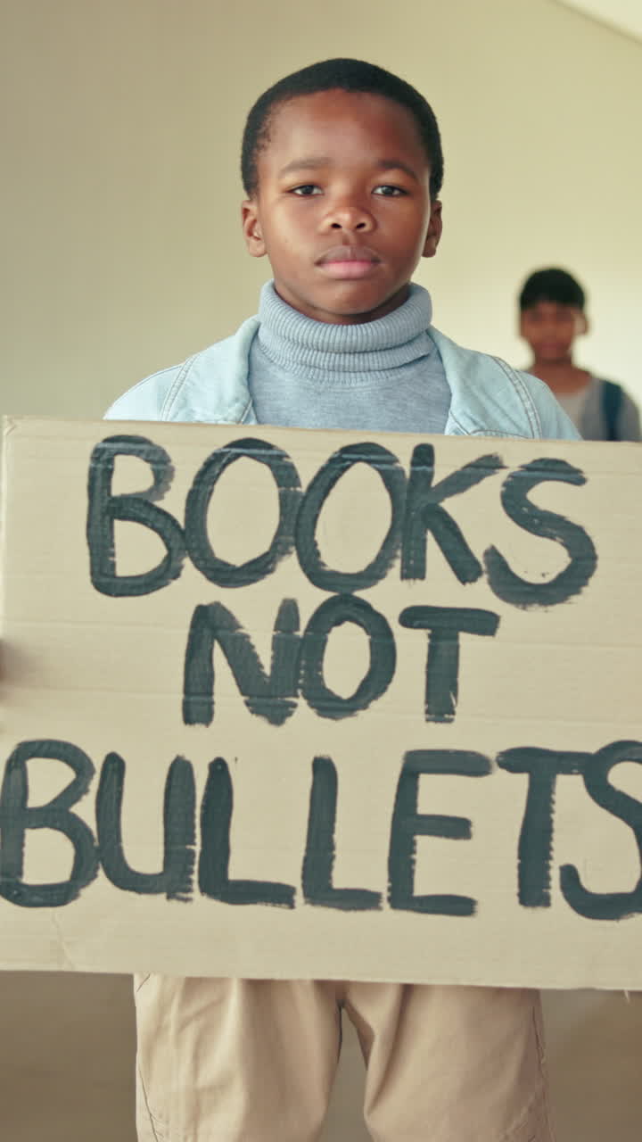 Young Boy Holding 'Books Not Bullets' Protest Sign