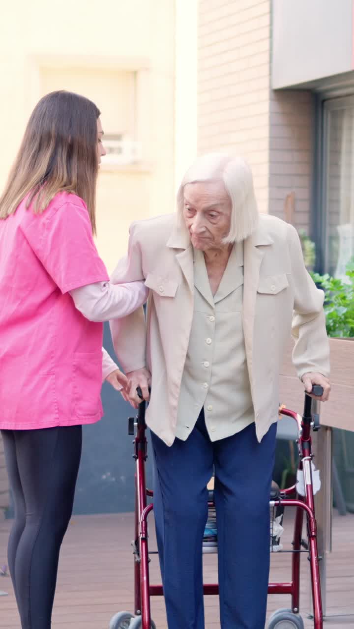 Elderly woman assisted by caregiver with walker