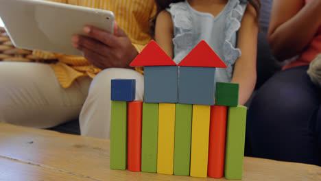 mid section of girl sitting on the couch and playing with building blocks in a comfortable home 4k