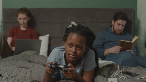 niña jugando videojuegos en la cama en el dormitorio