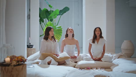 serene girls practicing yoga on private class. relaxed sisters in lotus position