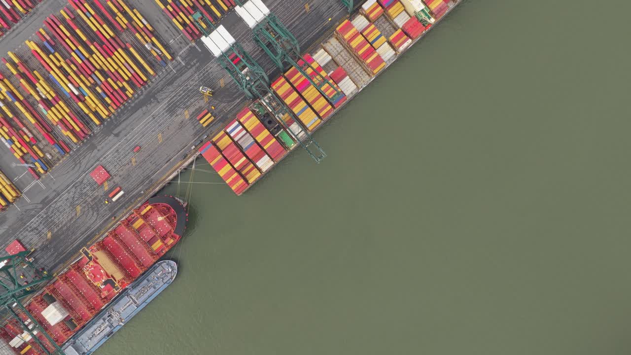 Drone aerial of industrial port logistics hub with vessels and containers