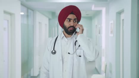 serious sikh indian doctor talking on call