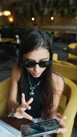 young woman using phone in a cafe