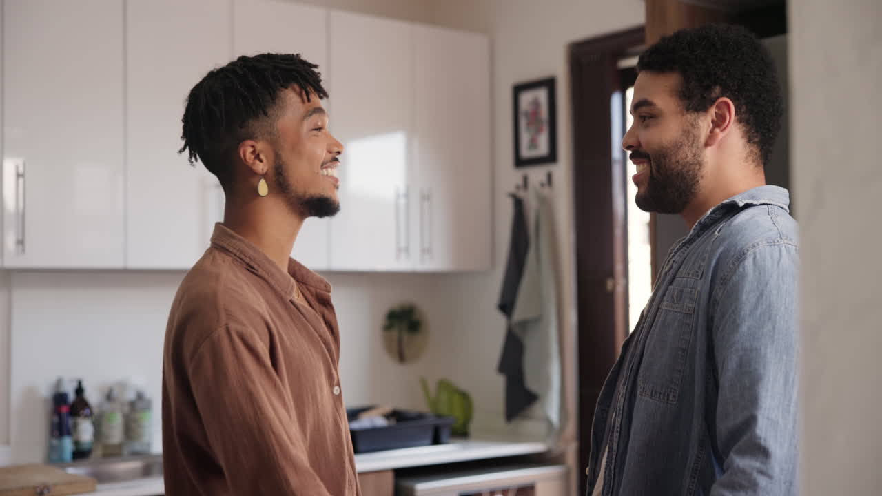 una pareja feliz hablando en la cocina.