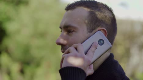 hombre joven hablando en el teléfono inteligente al aire libre