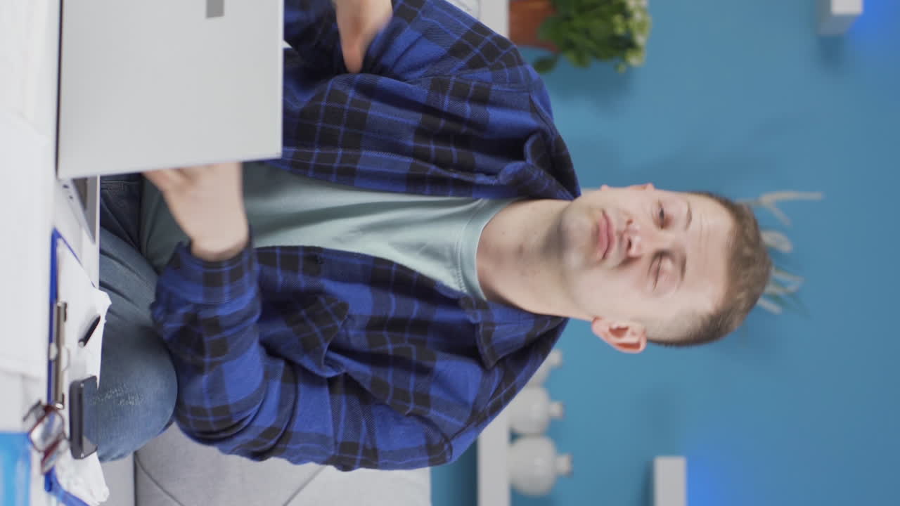 video vertical de un trabajador de oficina en casa haciendo un gesto negativo a la cámara.