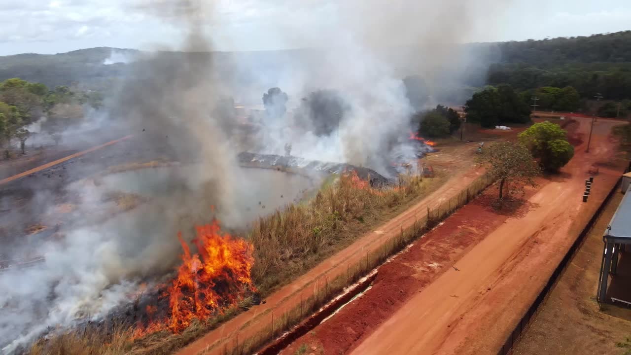 Aerial clip of a wild grass fire and smoke at the edge of a remote community in Cape York, Australia. Clip 5
