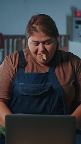 overweight woman working on laptop while eating