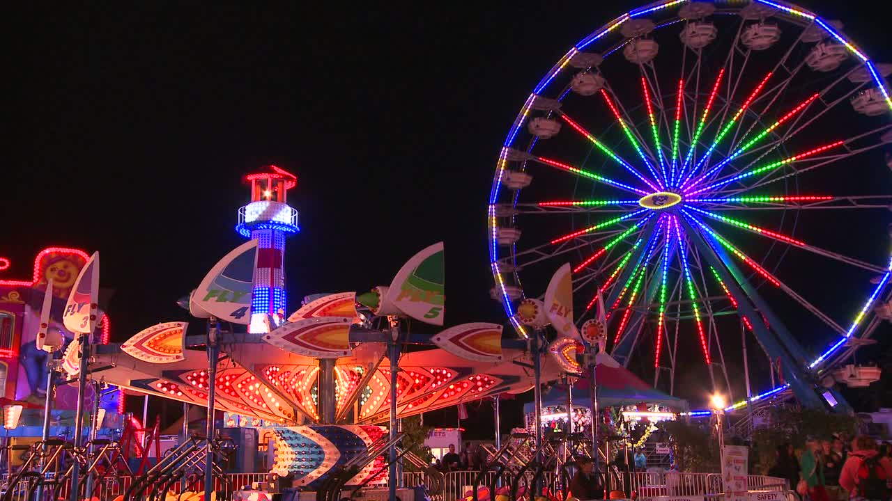 колесо обозрения и аттракционы на ночном карнавале