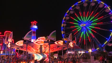 a ferris wheel an rides at a carnival at night