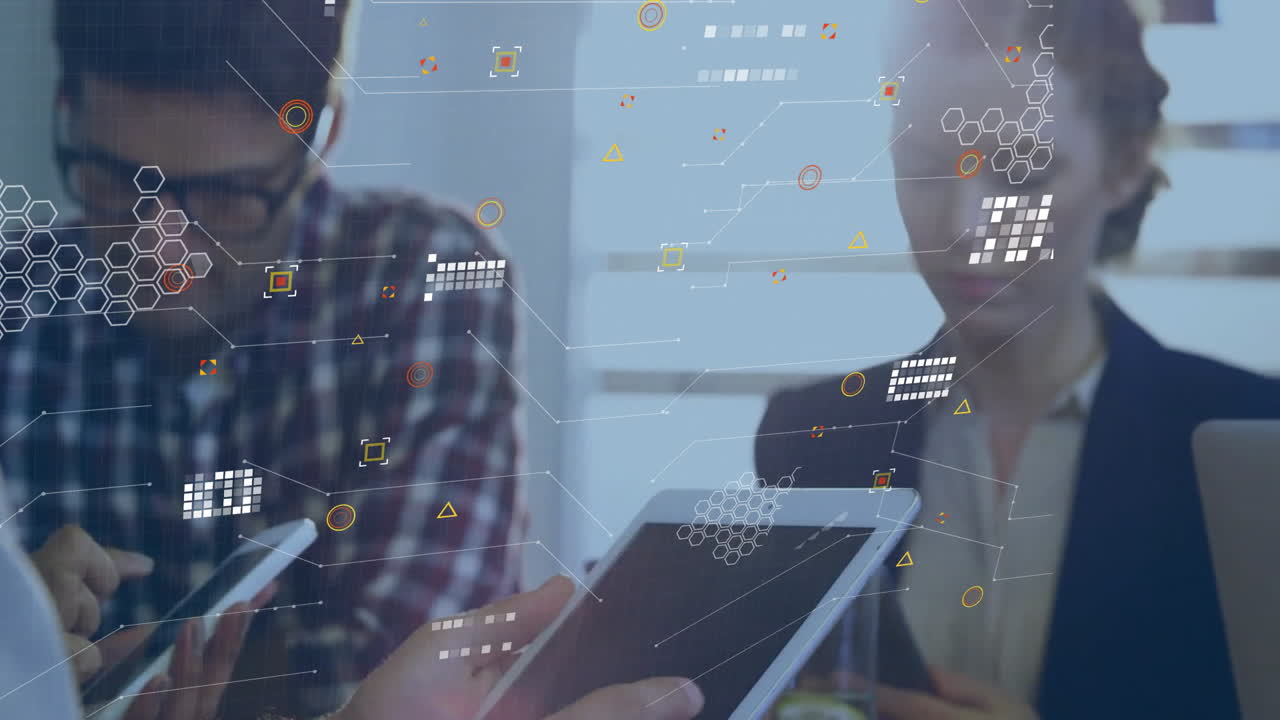 Animation of various symbols over caucasian colleagues working over digital tablets in meeting