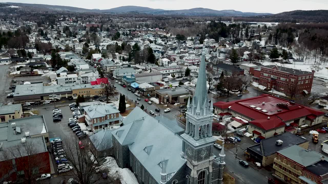 Aerial winter shot panning down on a cute little parish in St-Raymond, Quebec, Canada