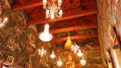 chandeliers illuminate ornate temple interior with murals