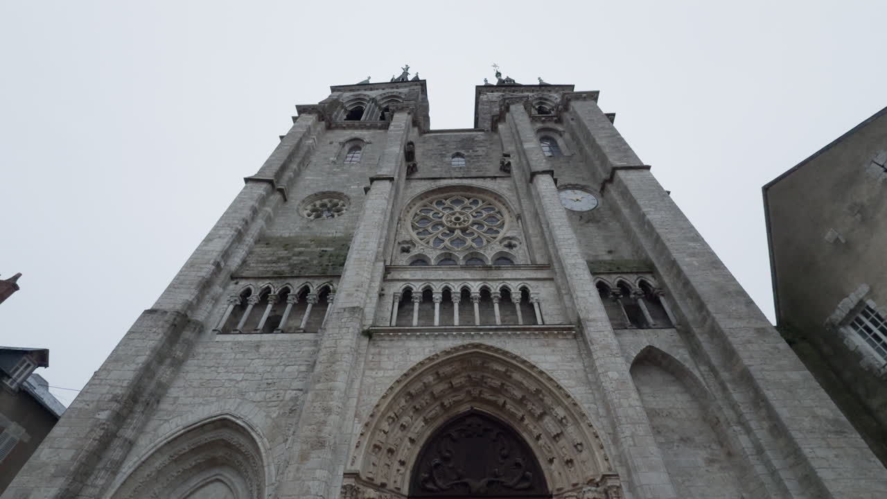 둥이 탑과 복잡한 고 양식의 세부 사항이 있는 역사적인 교회 정면