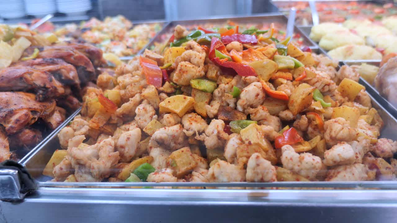 Pollo, patate e peperoni preparati esposti a buffet