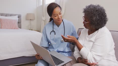 mixed race woman being visited at home by a nurse. social distancing and self isolation in quarantin