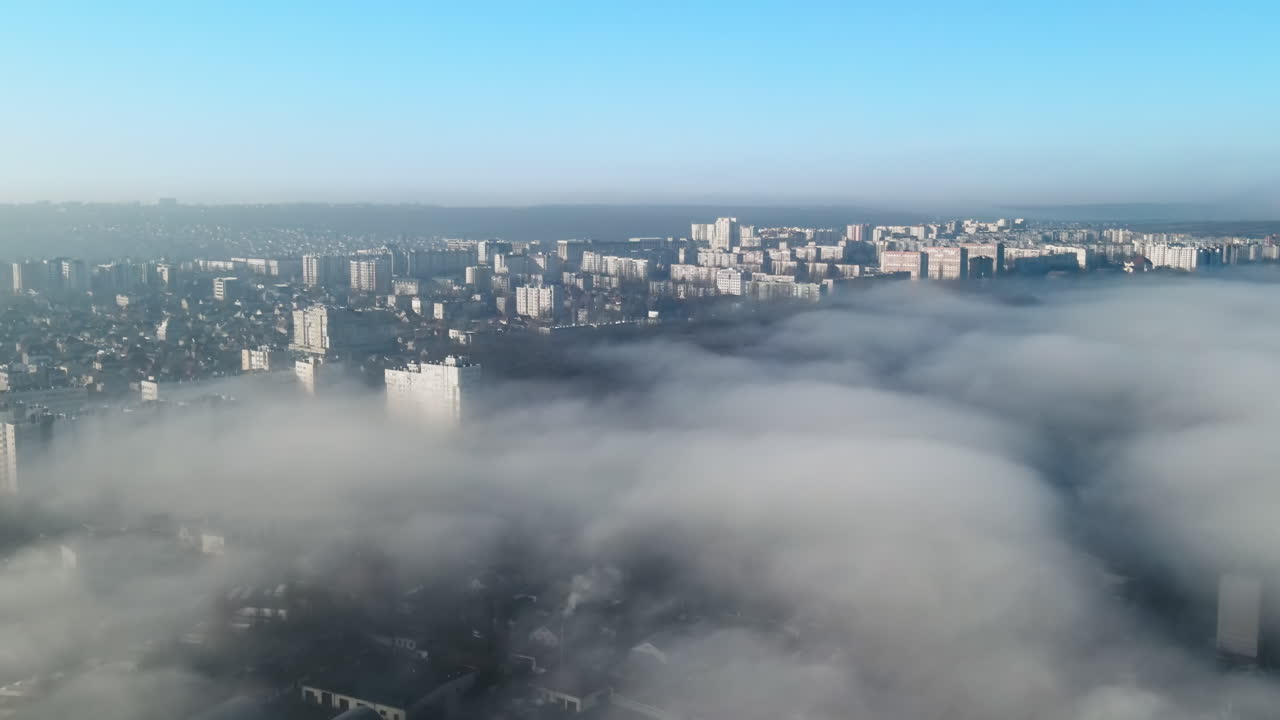 Aerial drone view above the clouds with buildings visible through, Chisinau, Moldova
