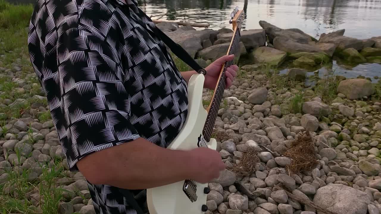 Man Playing Guitar by the Lake