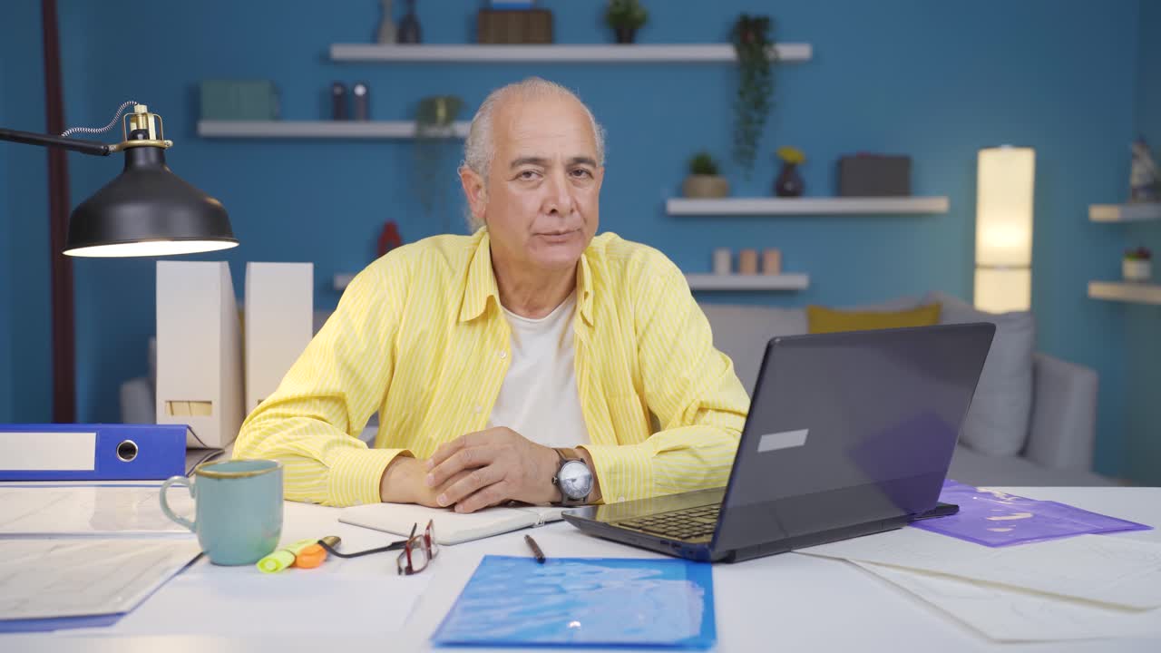 Home office worker old man nods to the camera, says no, no.