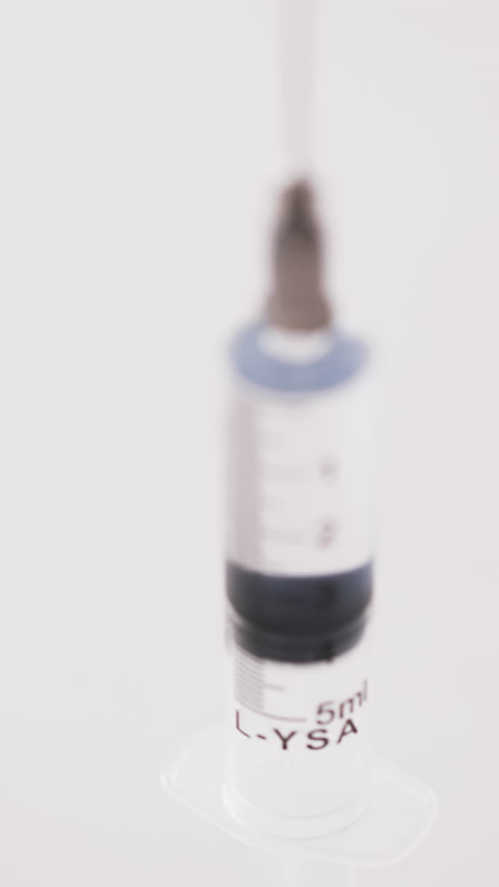 Vertical video of laboratory syringe with copy space on white background