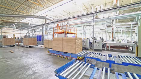 an electric loader puts on the metal pallet a pile of parquet boards under the client's order in the warehouse.