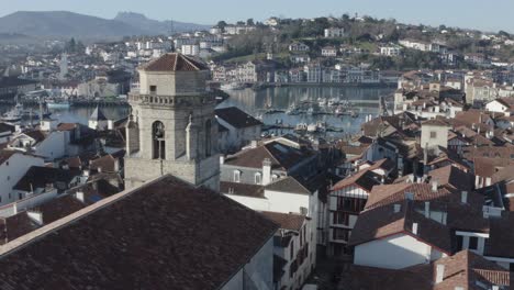 Saint-Jean-Baptiste church, Saint-Jean-de-Luz historic centre, cityscape, France. Aerial forward descending