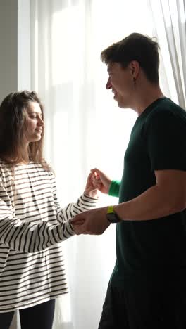 pareja interactuando cerca de una ventana