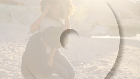 animation overlaying scene, couple walking on beach with abstract shapes