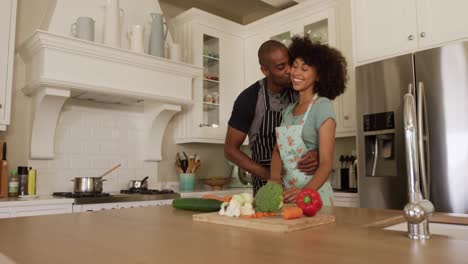 happy mixed race couple cooking and dancing in their kitchen