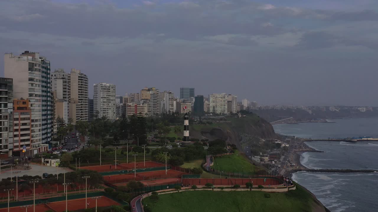Ripresa aerea di edifici e spiaggia all'ora del crepuscolo, scattata sulla costa di Costa Verde a Lima - Perù.