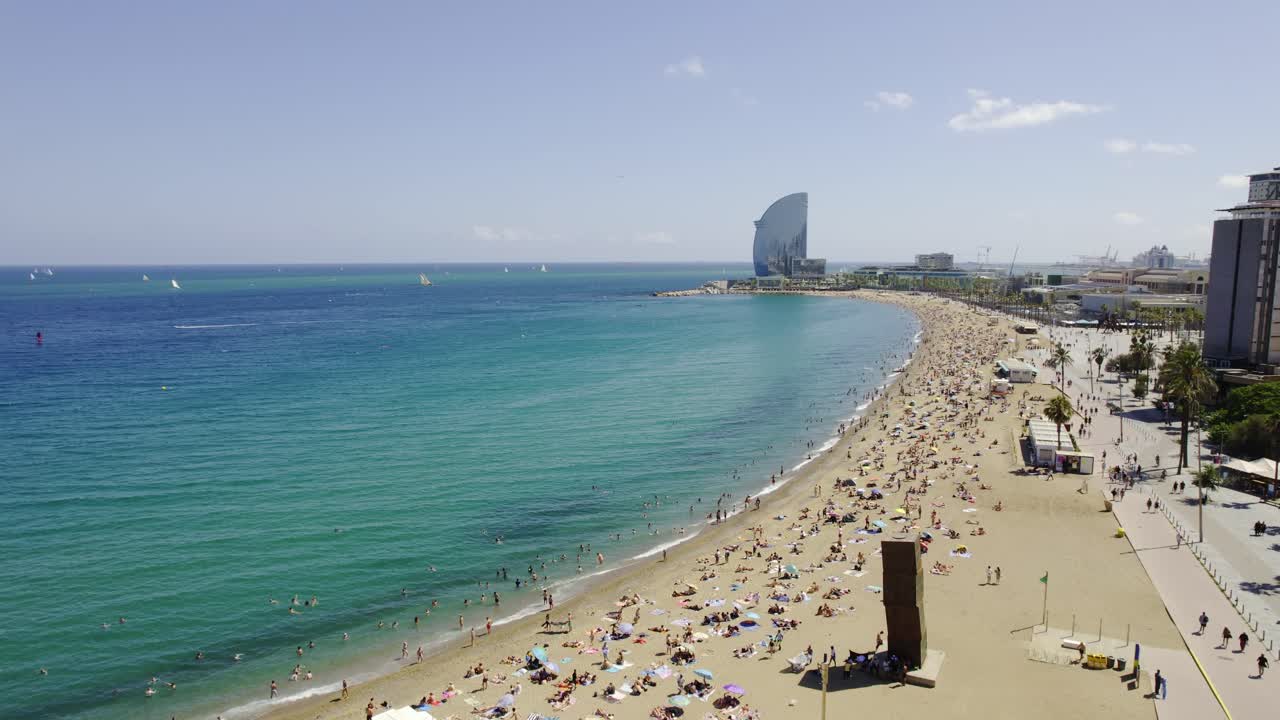 Aerial view of a busy beach in Barcelona, Spain, on a bright summer day
