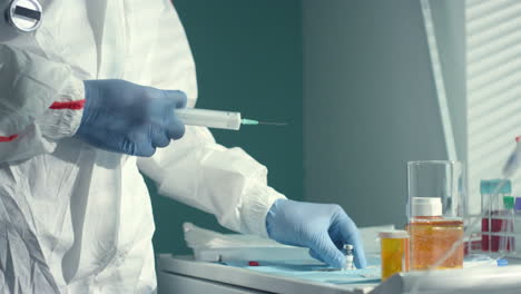 doctor fill medical syringe with vaccine fluid in clinic infectious department.