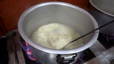 stir frying garlic in a large pan by a professional cook in slow motion