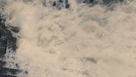 aerial view of white water rushing down river and waterfall in slow motion 40fps