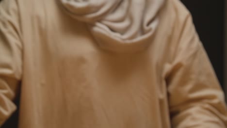 fotografía de estudio de un hombre vestido con túnicas, cabello largo y barba que representa la figura de jesucristo rompiendo el pan 1