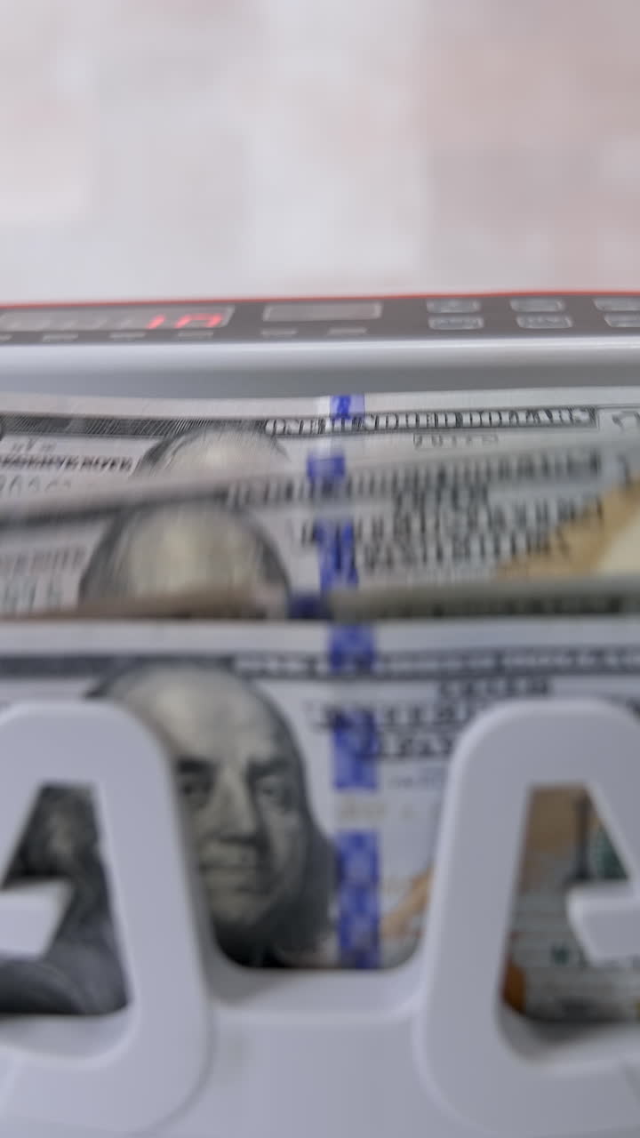 Currency counting machine counts dollar bills. Money counting equipment for paper money calculation. Currency exchange of one hundred dollars. Front view. Vertical video