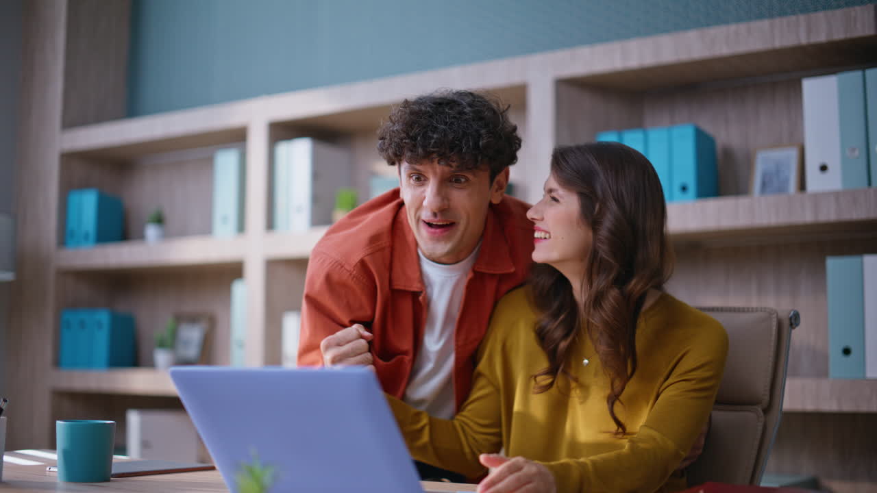 Excited coworkers rejoicing achievement collaborating on project office closeup
