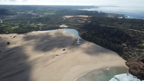 Drone-Panea-Sobre-La-Increíble-Playa-De-Bordeira-En-El-Algarve-En-Portugal,-Olas-En-La-Bahía-Con-Clima-Soleado