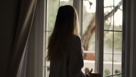 Mujer-Abriendo-Cortinas-En-La-Habitación-Del-Hotel-Saliendo-Al-Balcón,-Cámara-Lenta