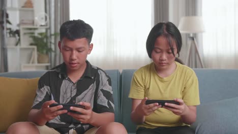 siblings playing on smartphones
