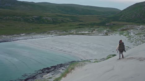 vista trasera de una persona caminando en la arena blanca en noruega - toma aérea