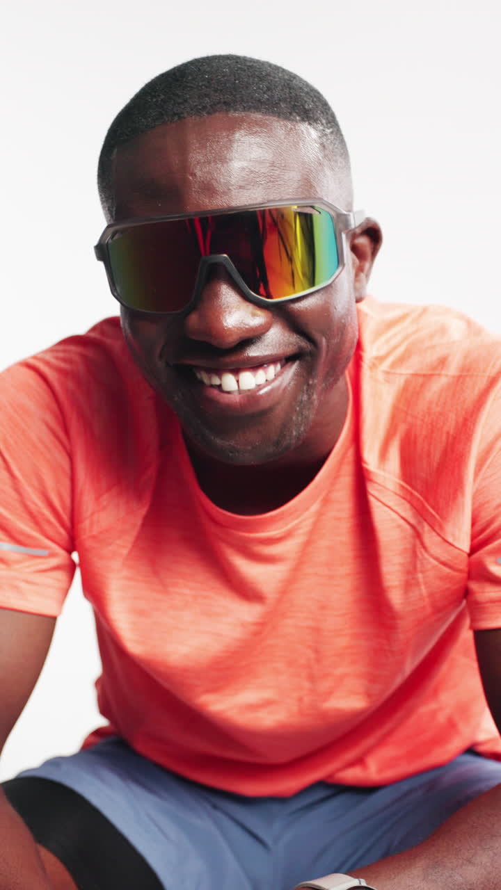 Happy Black Man in Sporty Sunglasses Smiling at Camera