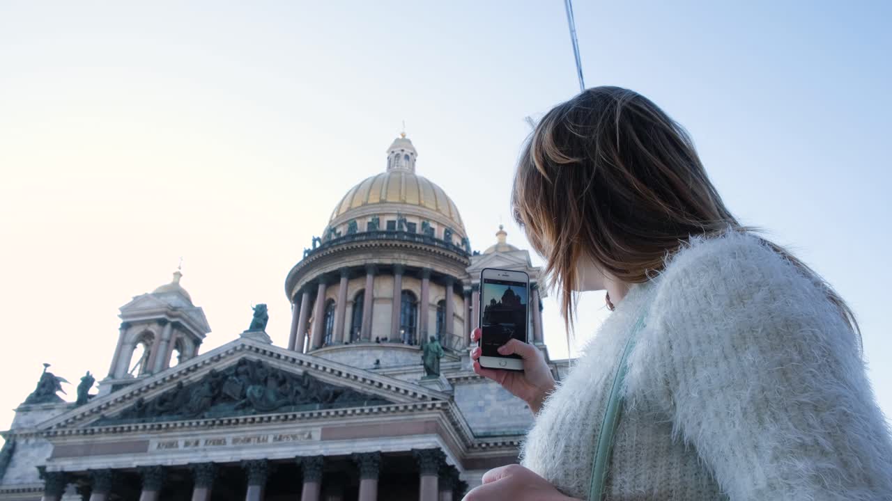 세인트 페테르부르크 의 교회 앞 에서 전화 를 사용하는 여자