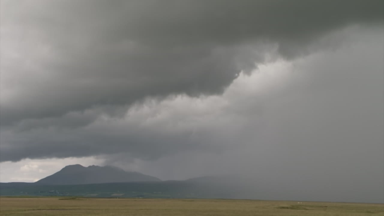 time lapse of clouds and rain over a hilly landscape without trees in Iceland