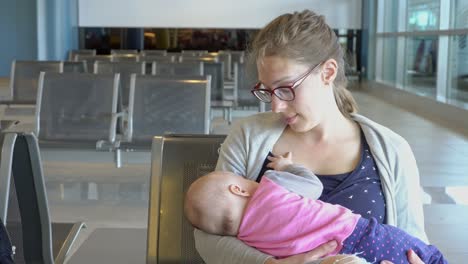 a woman breastfeeding her child at the airport