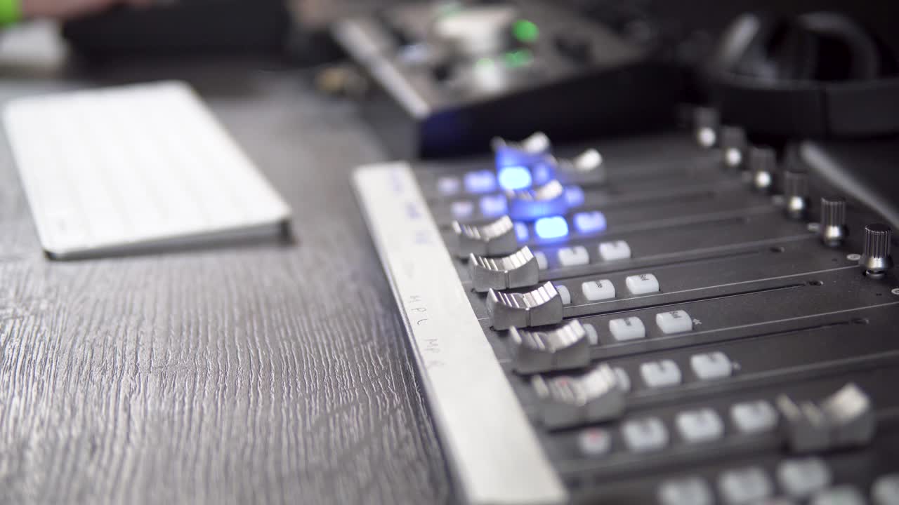 A close-up of a live audio mixer with no operator, showcasing the mixing desk, audio controls, and sound adjustments. Perfect for highlighting the technical setup of a live performance