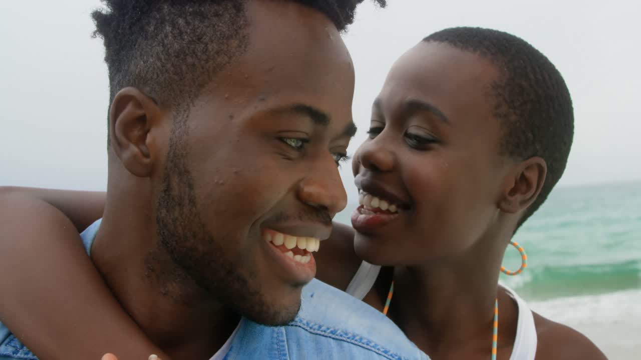 primer plano de una pareja afroamericana divirtiéndose en la playa 4k