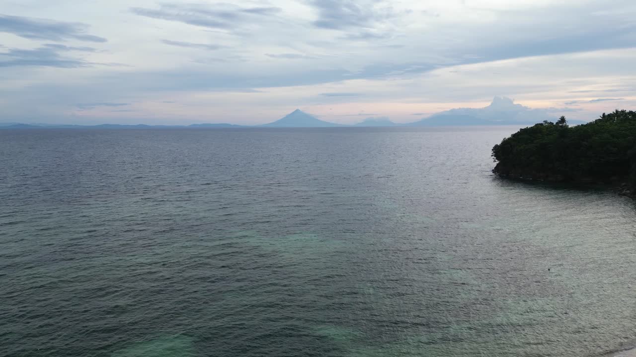 aérea, estableciendo una toma de drones de una playa impresionante con la silueta del volcán mayon en el fondo durante el anochecer, catanduanes, filipinas